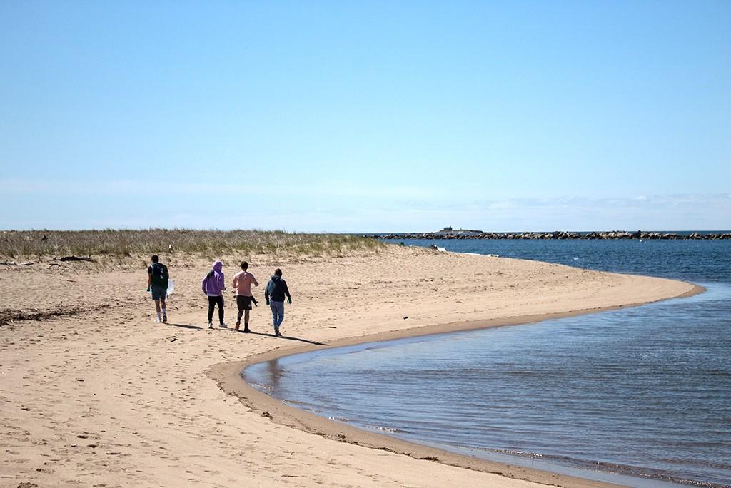 四个东北大学的学生走在海边的沙滩上